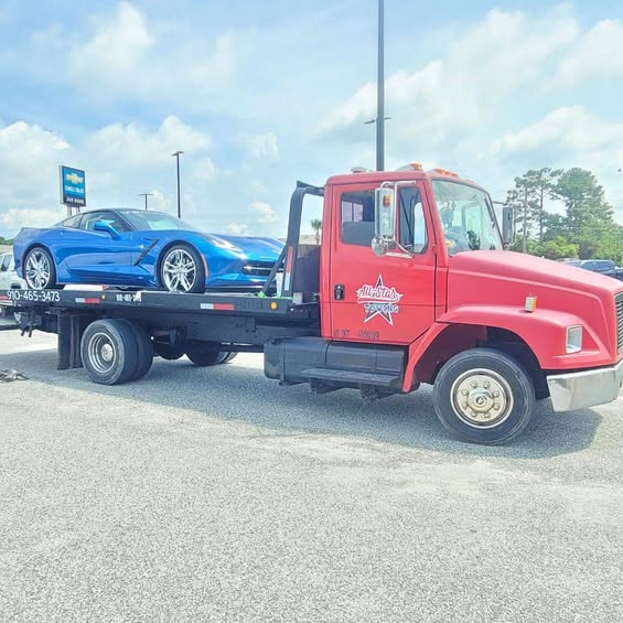 All Star Towing company truck carrying a blue car