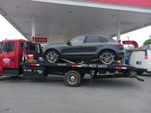 All Star Towing company truck bringing a vehicle to a gas station