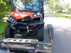 A damaged golf cart ready to be hauled by All Star Towing